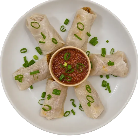 Rolled gluten-free momo with translucent wrappers, fanned around a bowl of house chutney