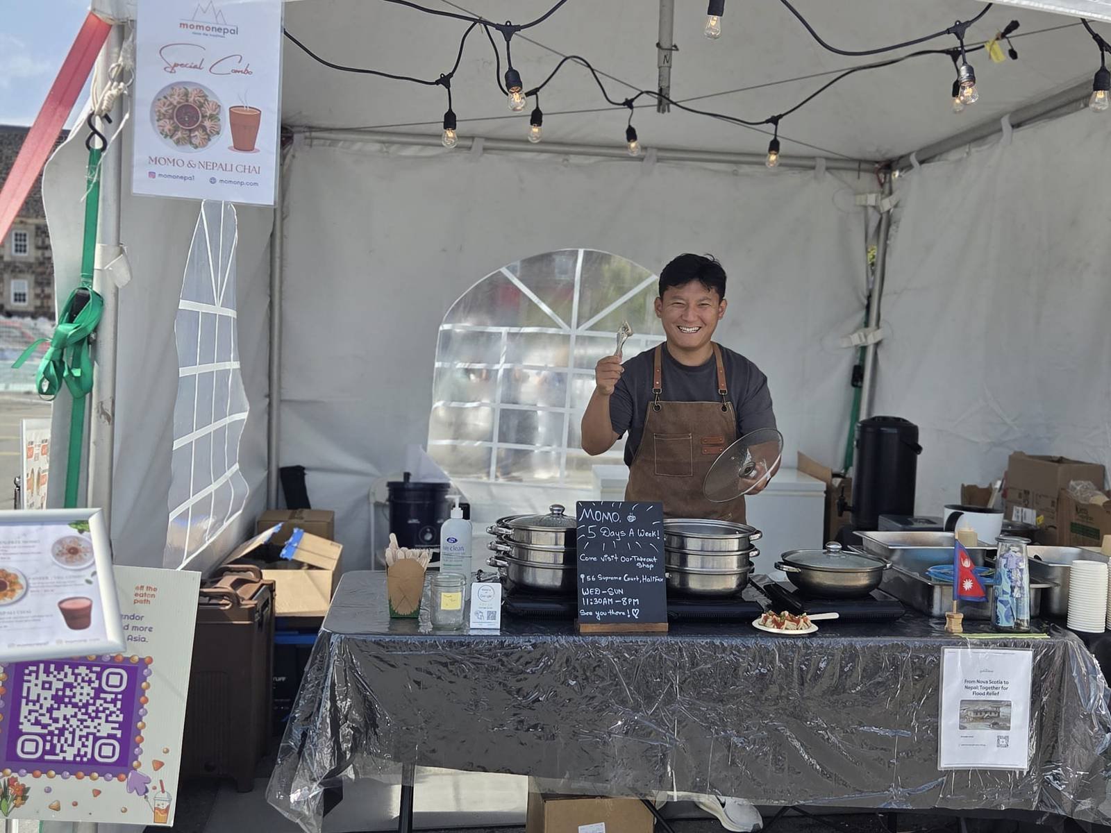 Sujit at the MomoNepal tent stall at Taste Asia, steamers of momo and a Nepal flag on the table